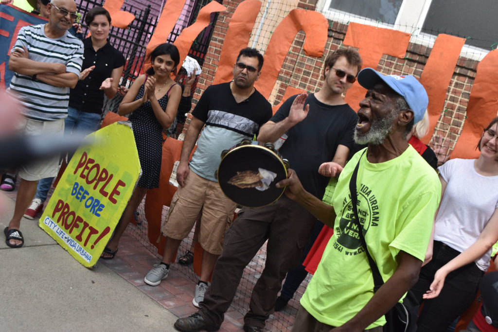 Bruce Green of the Stony Brook Tenants Association (right) speaks at the City Life/Vida Urbana rally to support renters fighting hikes of nearly 50 percent at 33 Park St., Malden, Aug. 3, 2019. (Greg Cook)