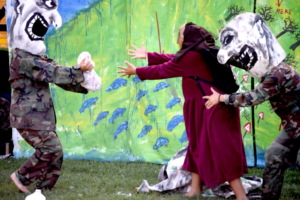 Immigration agents kidnap a migrant mother's baby during Bread and Puppet Theater's "Diagonal Life Circus" at Cambridge Common, Aug. 31, 2019. (Greg Cook)