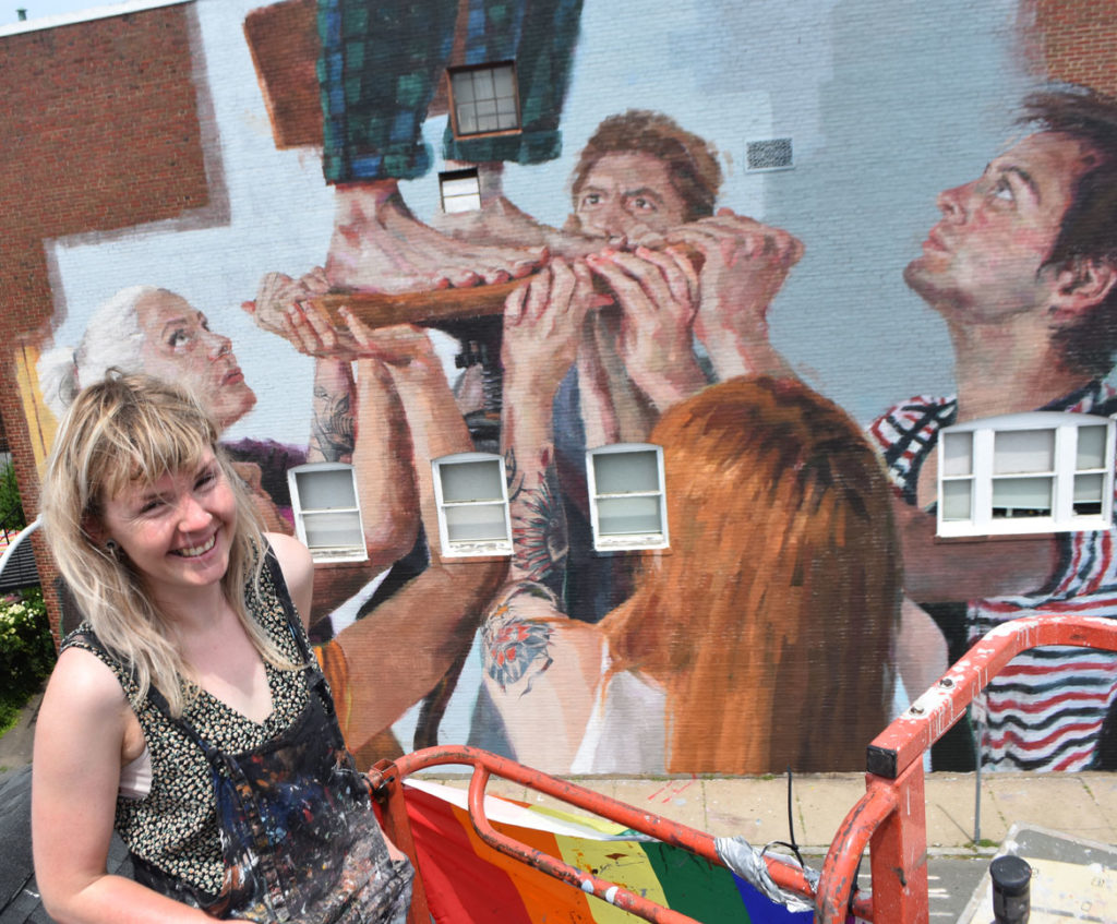 Helen Bur with her mural on the Cabot Theatre, Beverly, Massachusetts, July 20, 2019. (Greg Cook)