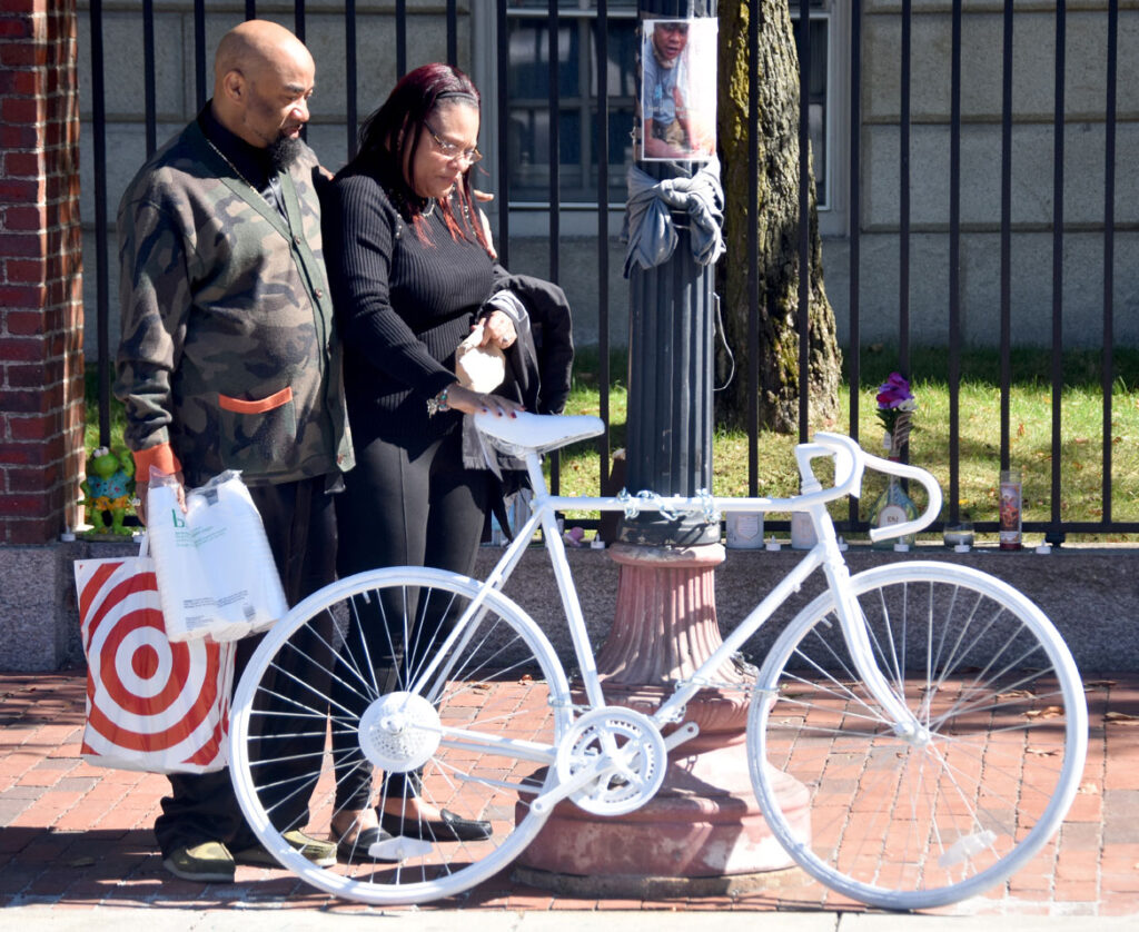 Donyell Chase-Willis and her fiancé visit the ghost bike placed in Cambridge's Harvard Square to remember her brother Darryl Willis, who was fatally struck by a truck there on Aug. 18. Sept. 19, 2020. (© Greg Cook photo)