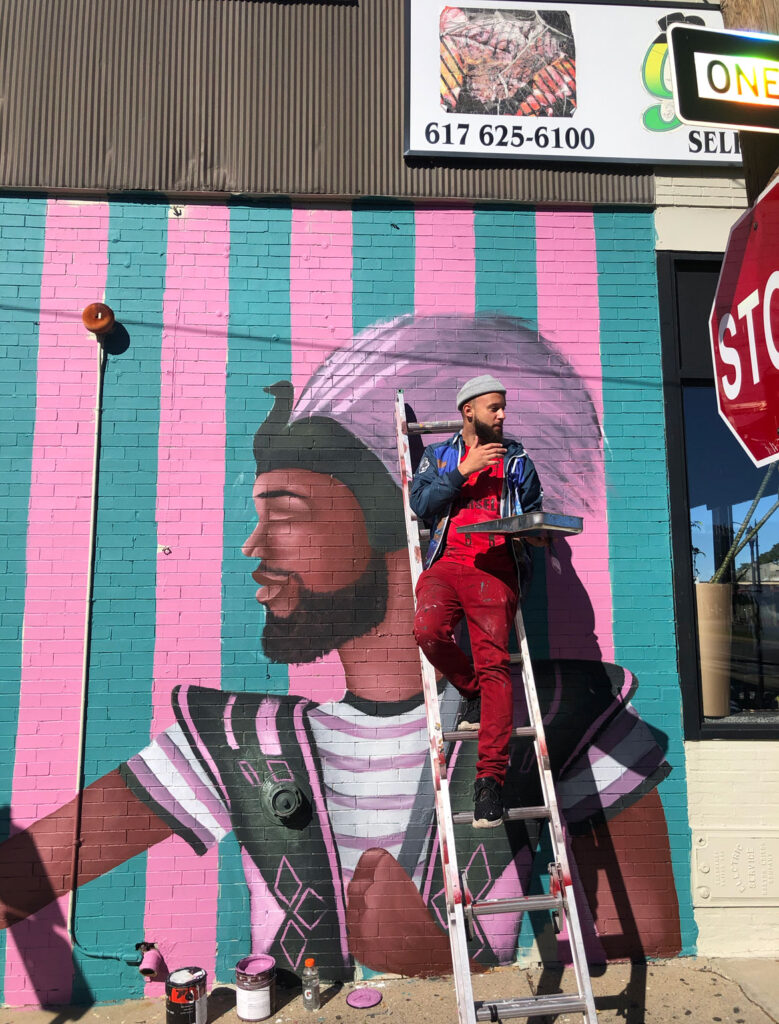 Alexandre Keto paints his "Doña Patria" mural at 102 Broadway, Somerville, October 2020. (Photo by Iaritza Menjivar/Somerville Arts Council)
