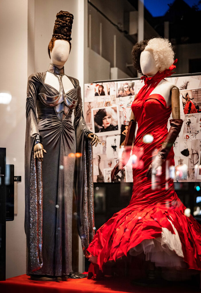 “Baroness Viking Gala Look” worn by Baroness von Hellman (Emma Thompson) and "Red Dress" worn by Cruella (played by Emma Stone" in Disney's 2021 ilm "Cruella," on view at Boston’s School of Fashion Design. (Disney / photo: Aram Boghosian)