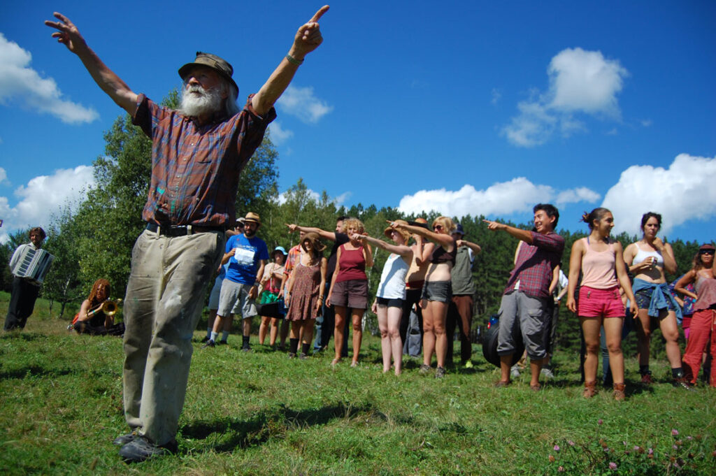 Genevieve Yeuillaz (background, in red top) participates in Bread and Puppet pageant rehearsal, Glover, Vermont, Aug. 22, 2015. (©Greg Cook photo)