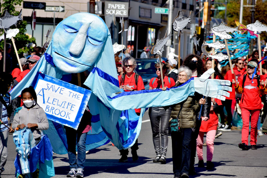 The Puppeteers Cooperative promotes the message "Save Alewife Brook" in the Honk parade from Somerville's Davis Square to Cambridge's Harvard Square, Sunday, Oct 9, 2022 (©Greg Cook photo)