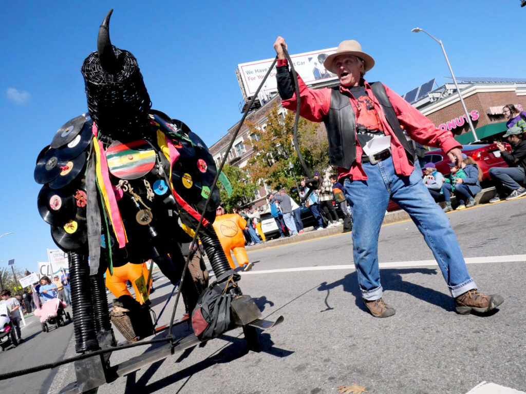 Robert Smith walks with one of his sculptures in the Honk parade from Somerville's Davis Square to Cambridge's Harvard Square, Sunday, Oct 9, 2022 (©Greg Cook photo)