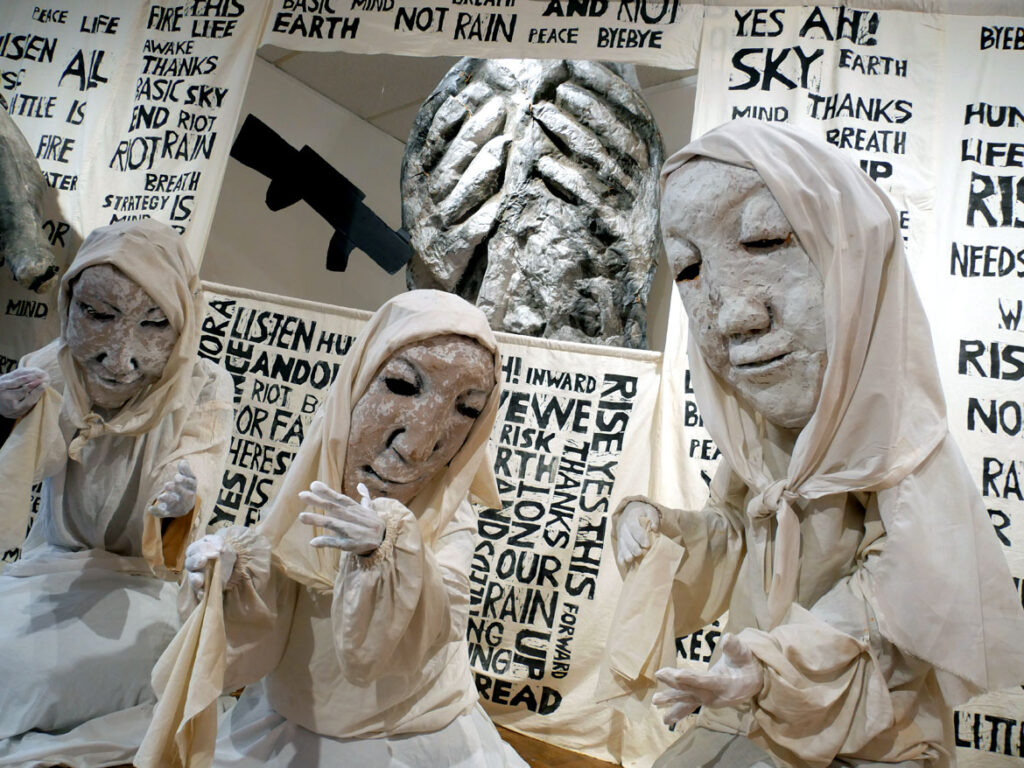 Puppets, costumes and woodcut stage curtains from the 2017 performance “The Basic Bye-bye Show” in the exhibition “Bread and Puppet Theater: Art and Activism in Five Acts” at Salem State University, November 2022. (©Greg Cook photo)