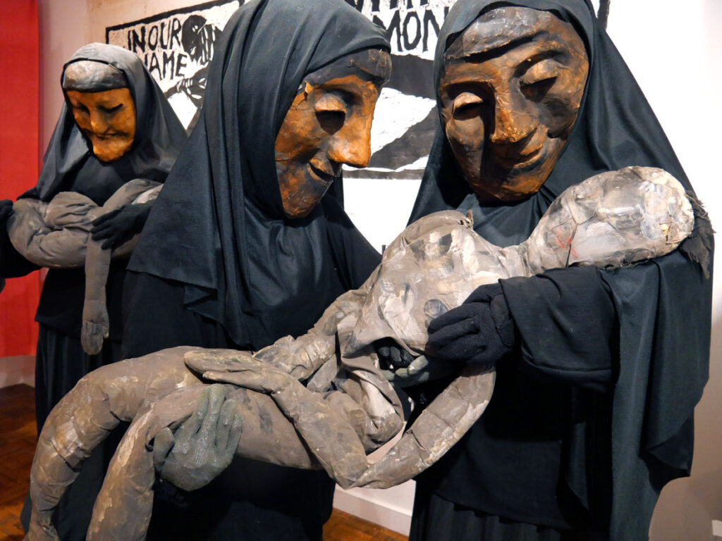 Iraqi women masks in the exhibition “Bread and Puppet Theater: Art and Activism in Five Acts” at Salem State University, November 2022. (©Greg Cook photo)