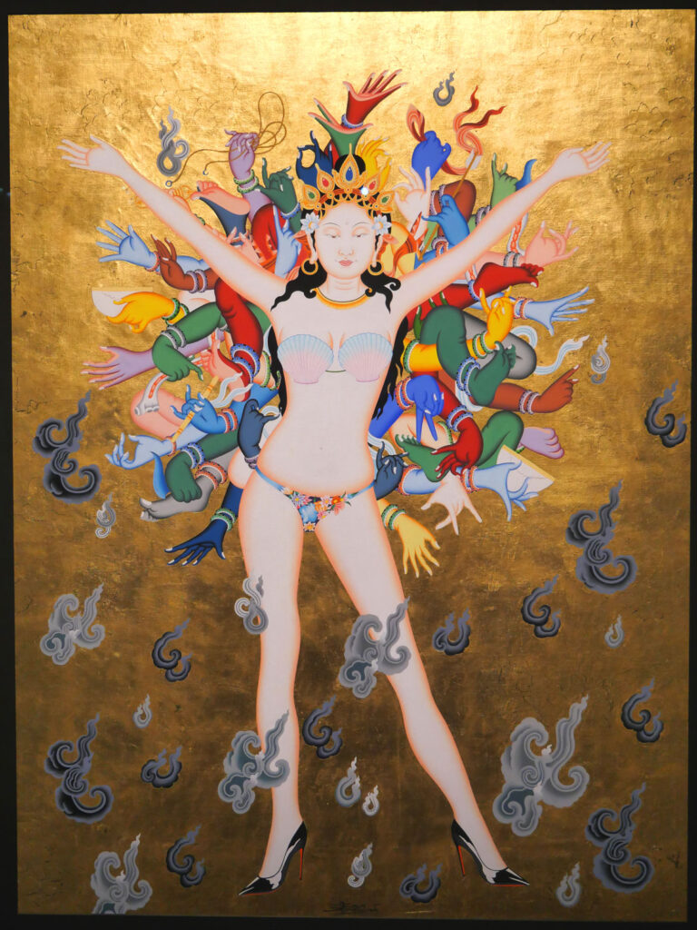 Tsherin Sherpa, "Tara Gaga," 2016, Gold leaf, acrylic, and ink on cotton. A friend’s young daughter asked Sherpa why there were so few women heroes in Himalayan contemporary art. His response was this figure who fuses the Bodhisattva Tara with modern-day pop musician Lady Gaga, pictured here in one of her most iconic outfits: an ensemble worn at the 2013 MTV Video Music Awards. With her arms out in unabashed confidence and pride, Tara Gaga drives away the ominous dark clouds of smoke with her radiant presence.