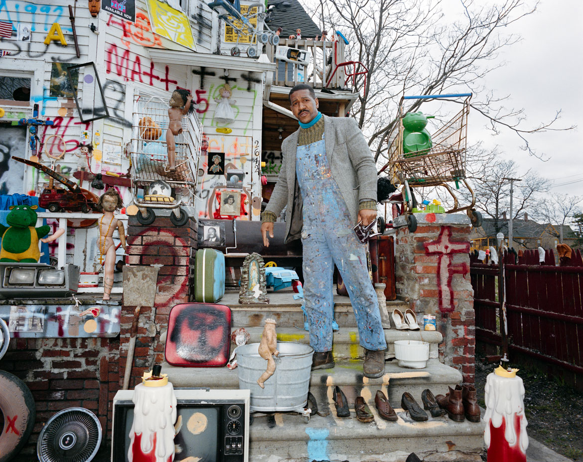 Ted Degener (American, b. 1948). Tyree Guyton on the steps of one of the homes included in The Heidelberg Project in Detroit, Michigan, 1997. Archival pigment print. Photo courtesy Ted Degener