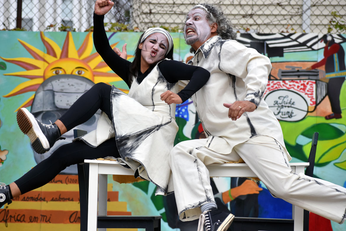 Agua, Sol y Sereno performs their humorous play “Comer" at Boston's Mozart Park, Sept. 15, 2023. (©Greg Cook photo)