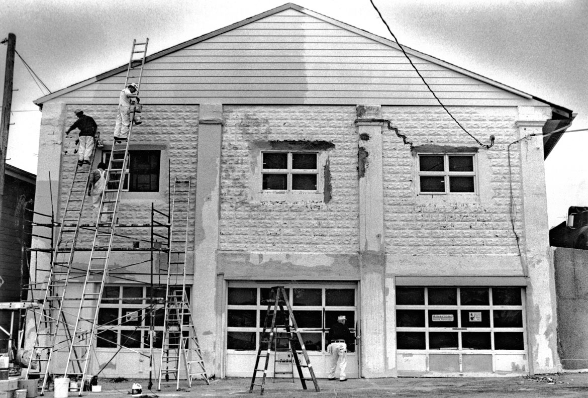 "Tally's gets a paint job from painters employed by Exxon," October 1984. Photograph by Mitch Eagan. In "Above the Fold" at the Cape Ann Museum, 2023.