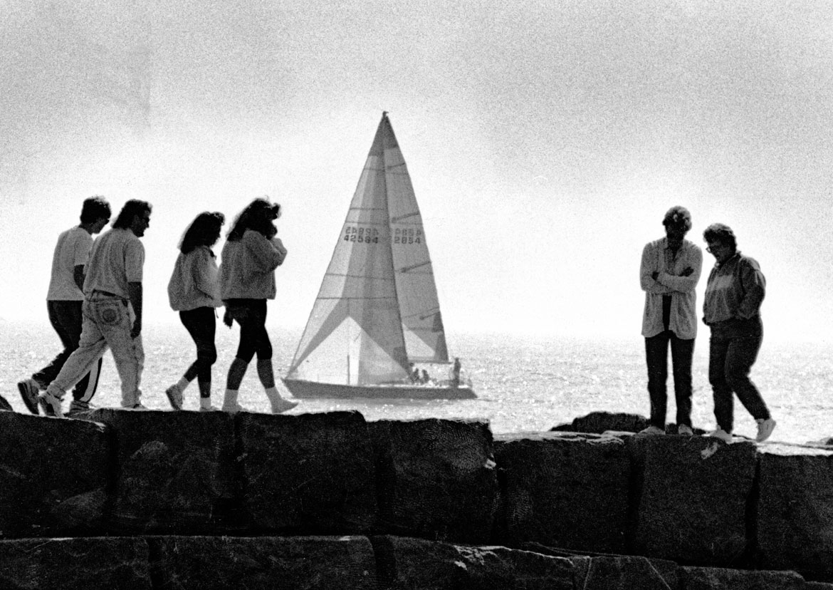 "Eastern Point: Dog Bar Breakwater was busy with activity as people flocked outside to enjoy the warm weather," April 23, 1990. Photograph by Amy Sweeney. In "Above the Fold" at the Cape Ann Museum, 2023.