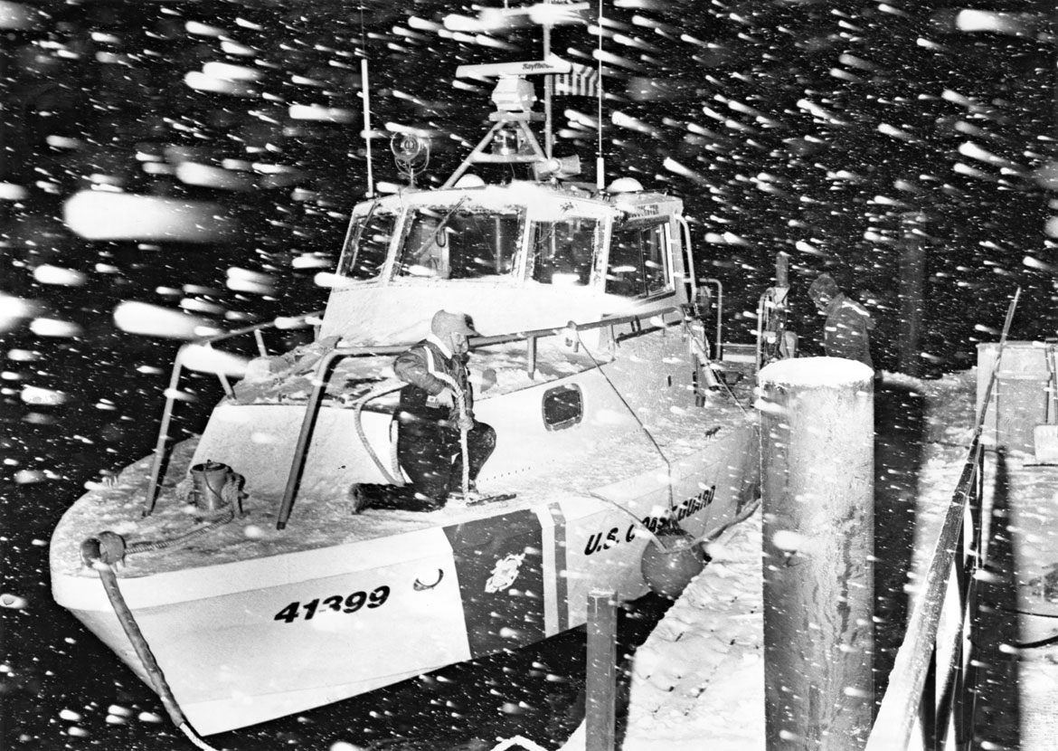 "U.S. Coast Guard boat is tied up at a dock during an evening snowstorm." Photograph by Bart Piscitello. In "Above the Fold" at the Cape Ann Museum, 2023.