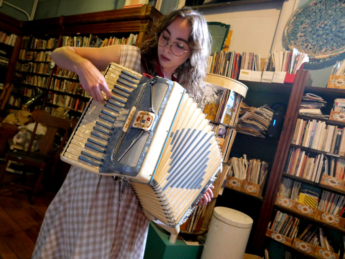 Natalie Robertson in the Dirt Palace library, Providence, August 2025. (©Greg Cook photo)