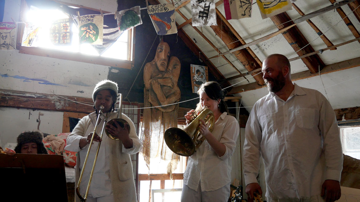 Bread and Puppet Theater band performs before presenting “Life and Death Precision Dances with Happiness Obligation Prologue” in the Ballroom at the Glover, Vermont, farm, Feb. 8, 2026. (©Greg Cook photo)