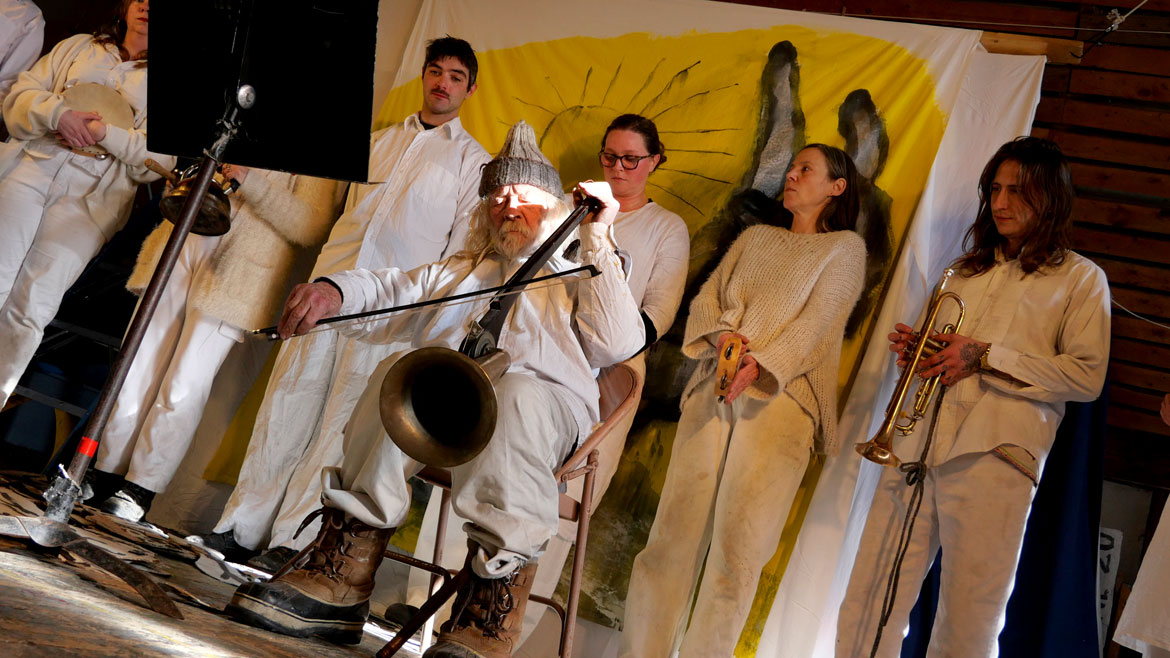Peter Schumann performs a fiddle sermon during Bread and Puppet Theater performance of “Life and Death Precision Dances” in the Ballroom at the Glover, Vermont, farm, Feb. 8, 2026. (©Greg Cook photo)