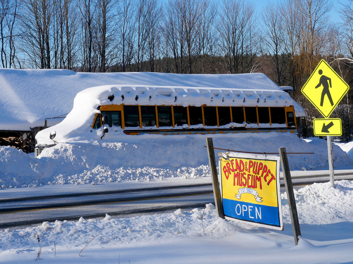 Bread and Puppet Theater bus snowed in across from puppeteers' house, Glover, Vermont, Feb. 9, 2026. (©Greg Cook photo)