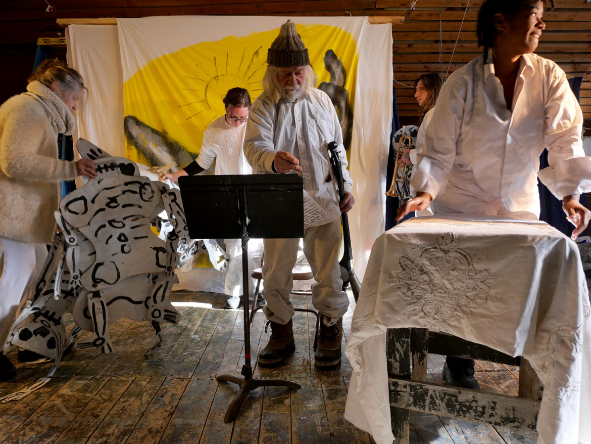 Bread and Puppet Theater co-founder Peter Schumann (center) and company conclude a performance of “Life and Death Precision Dances with Happiness Obligation Prologue" in the wood-stove-heated upstairs Ballroom at the company’s snowbound Glover, Vermont, farm, Feb. 8, 2026. (©Greg Cook photo)