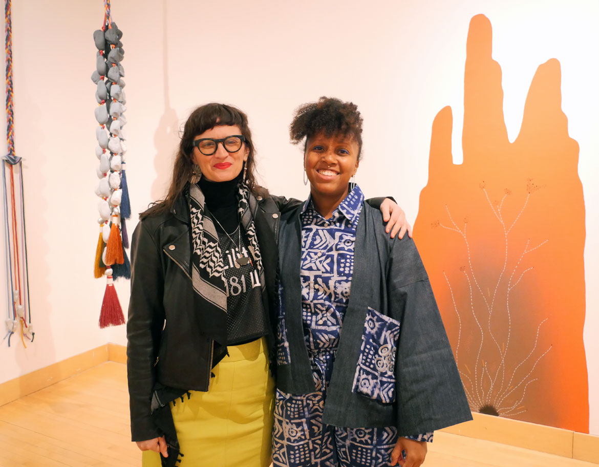 Maria Molteni (left) and Funlola Coker at "Cosmic Threads" exhibition at Merrimack College's McCoy Art Gallery, February 2026. (©Greg Cook photo)