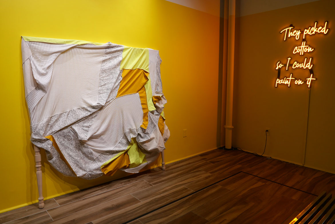 Destiny Palmer, (left) "The Burden Moving Forward," handwritten fabric and fabric remnants on wooden frame, and (right) "They Picked Cotton," LED lighting and acrylic.