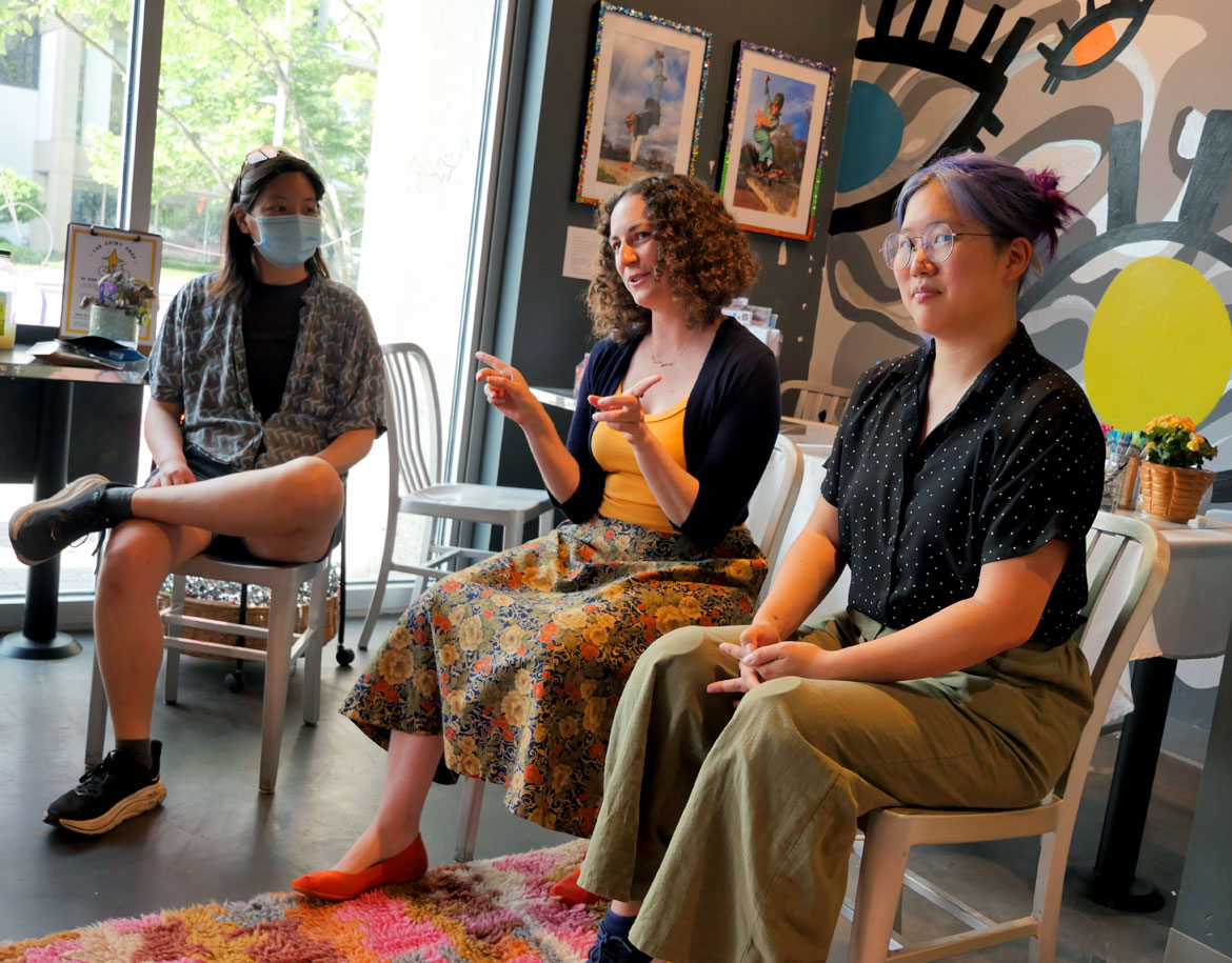 Stephanie Li (from left), SaraMarie Bottaro and Jane Kim Testa of the Rabbits of Realness lead a zine-making workshop at The Shiny Shop, June 11, 2026. (©Greg Cook photo)