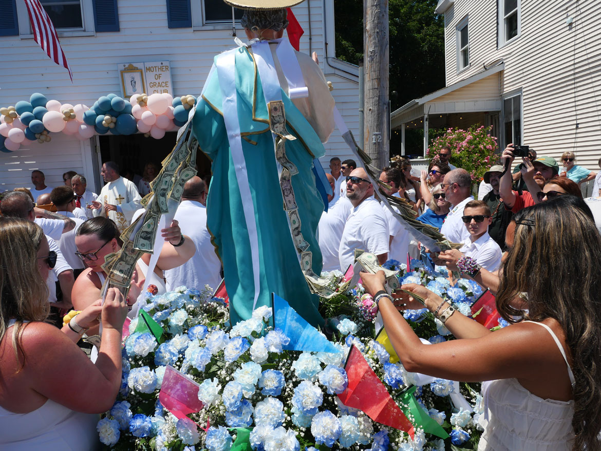 Pinning donations to the St. Peter statue during the Fiesta Sunday Procession, Gloucester, June 28, 2026. (©Greg Cook photo)