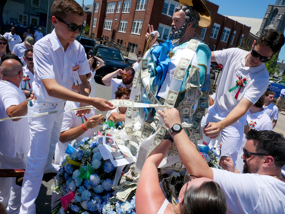 Pinning donations to the St. Peter statue during the Fiesta Sunday Procession, Gloucester, June 28, 2026. (©Greg Cook photo)