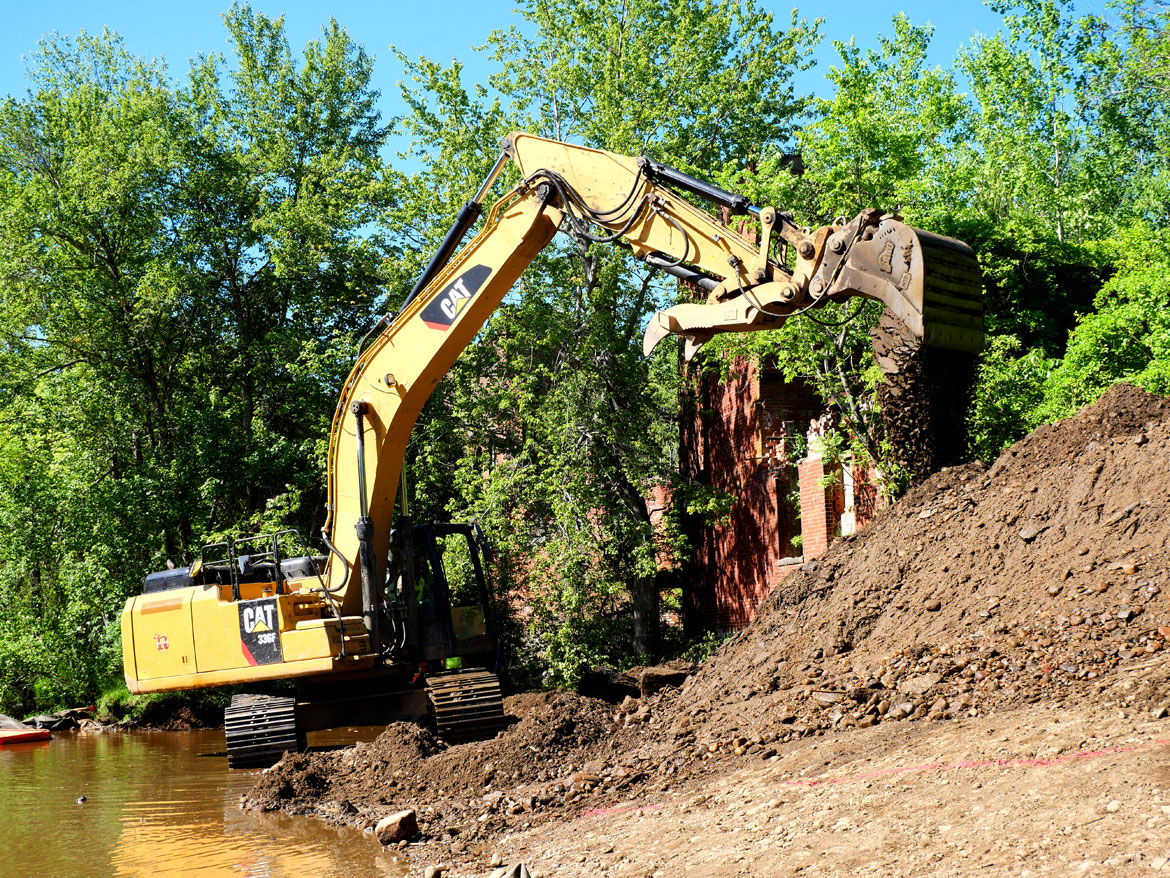 Earthmover reshapes the riverbank at the Wheelwright Dam, June 9, 2026. (©Greg Cook photo)