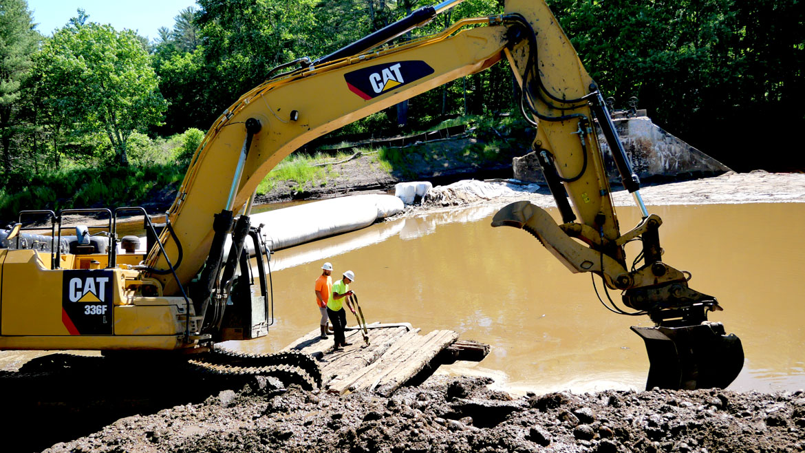 Earthmover reshapes the riverbank as little of the Wheelwright Dam remains, June 9, 2026. (©Greg Cook photo)