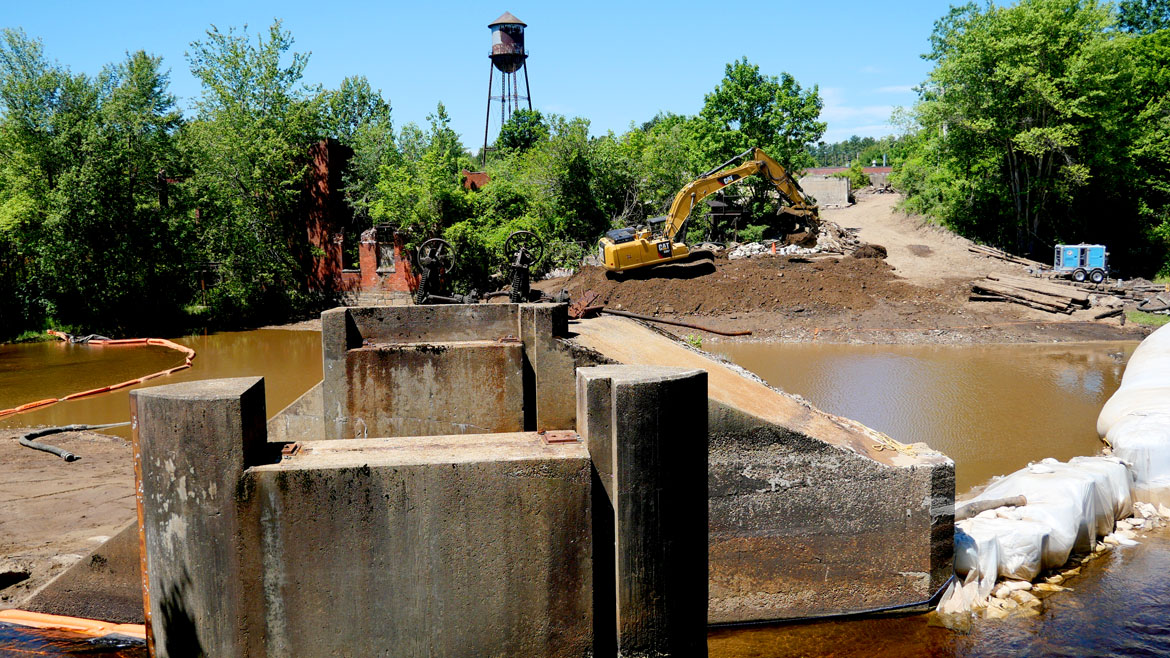 Earthmover reshapes the riverbank at the Wheelwright Dam, June 9, 2026. (©Greg Cook photo)