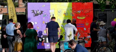 “All This, All at Once” mural by Ansis Puriņš and Blipblipbeep (Jennifer Puriņš) outside the Harvard Ed Portal in Allston, June 2026. (Greg Cook photo)