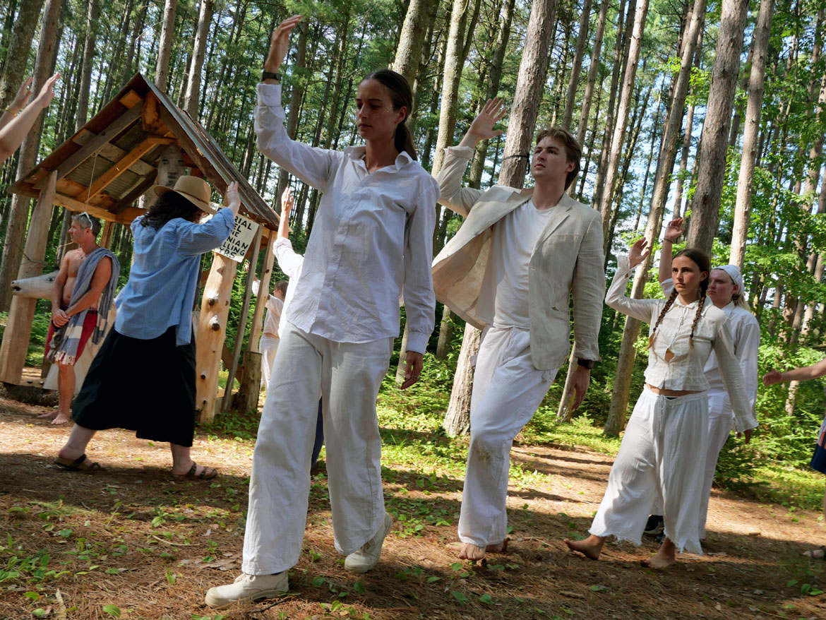 Long line dances in the Pine Forest during Bread and Puppet Theater's "Upside Down World Resurrection Pageant," performed on their Glover, Vermont, farm, July 26, 2026. (©Greg Cook photo)
