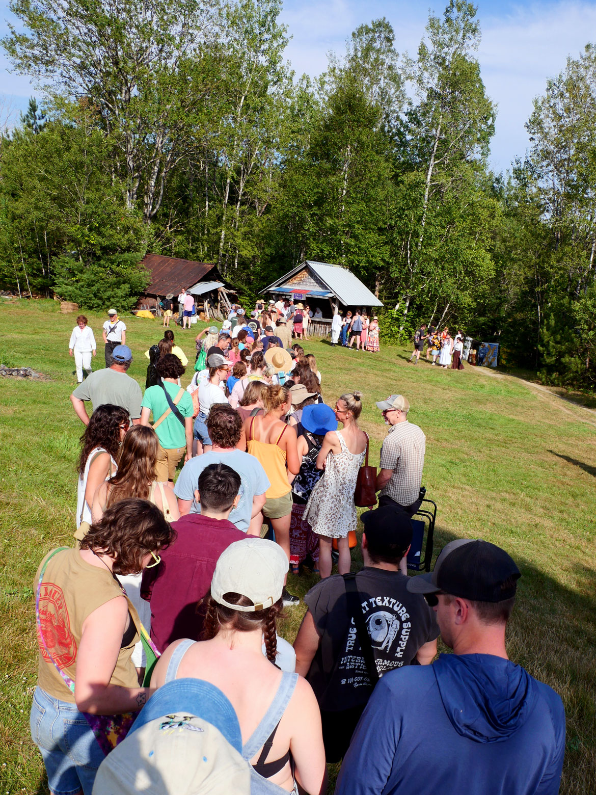 The line for the bread house after Bread and Puppet Theater's "Upside Down World Resurrection Pageant," performed on their Glover, Vermont, farm, July 26, 2026. (©Greg Cook photo)