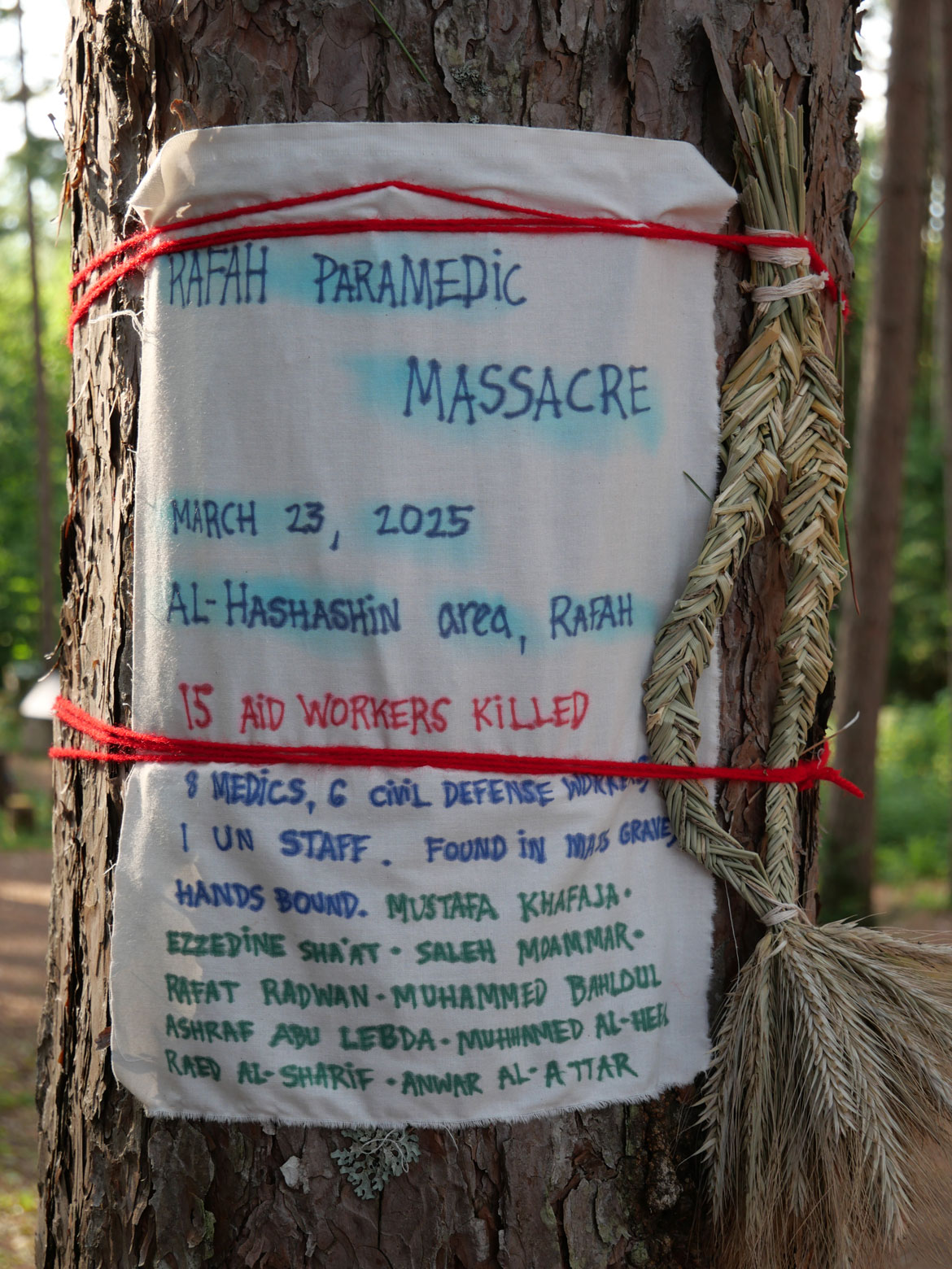 Memorial to killed Palestinians, tied to trees in the Pine Forest, for Bread and Puppet Theater's "Upside Down World Resurrection Pageant," performed on their Glover, Vermont, farm, July 26, 2026. (©Greg Cook photo)