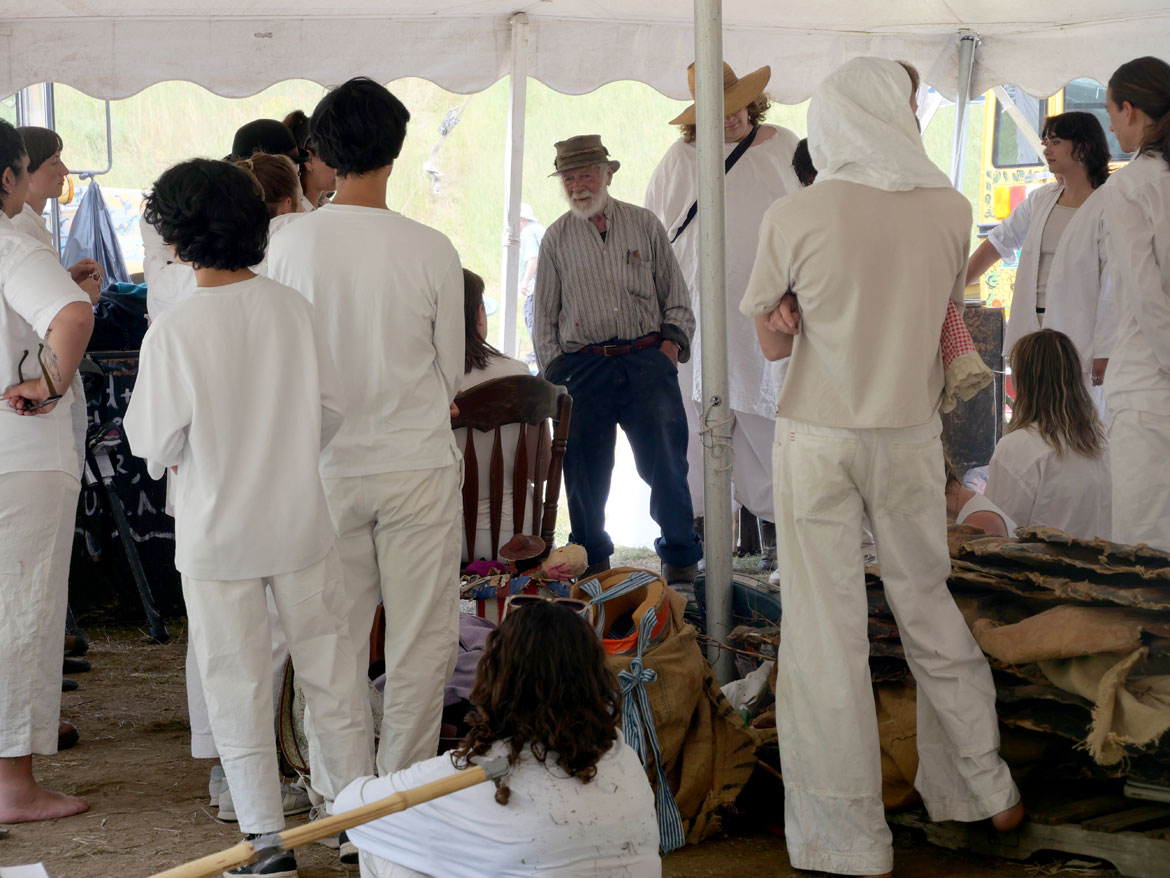 Peter Schumann gives last minute guidance backstage before the start of Bread & Puppet Theater’s “Upside Down World Circus” at the company's Glover, Vermont, farm, July 26, 2026. (©Greg Cook photo)
