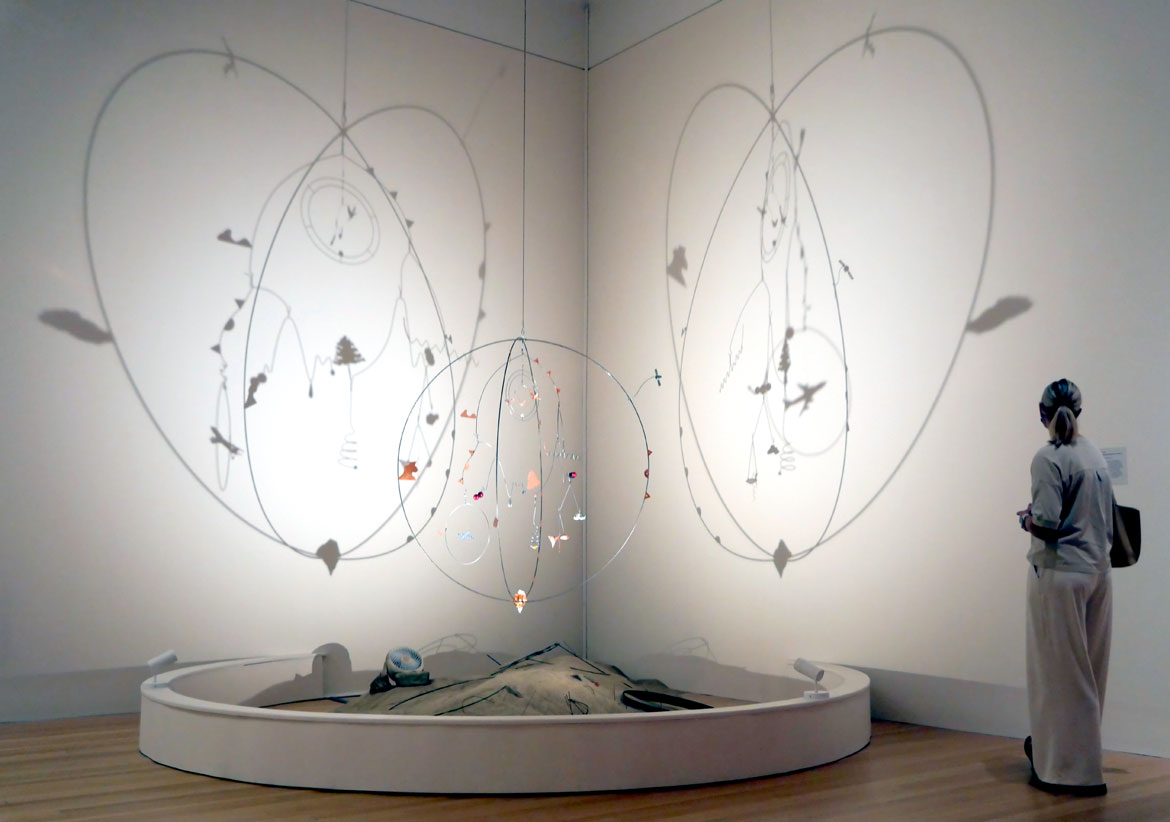 Andrew S. Yang, "Earthly Equipoise," 2025, kinetic sculpture made of steel, copper, brass, plastic, disco ball motor, and "Runaway Global Warming (the surface of Venus)," 2025, rock, sand, and found steel. (Greg Cook photo)
